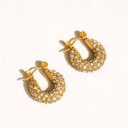 Gold hoop earrings with embedded stones on a white background